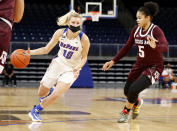 In this photo provided by DePaul Athletics, DePaul's Lexi Held (10) drives as Texas A&M's Jordan Nixon (5) defends during a women's NCAA college basketball game on Saturday, Nov. 28, 2020, in Chicago. It's a common sight to see players and coaches wear masks on the sideline so far this season during college basketball games to help prevent the spread of the coronavirus. The DePaul and Creighton women's basketball teams are among a few squads that have taken it a step further with their players wearing the masks while they are on the court playing. (Steve Woltmann/DePaul Athletics via AP)