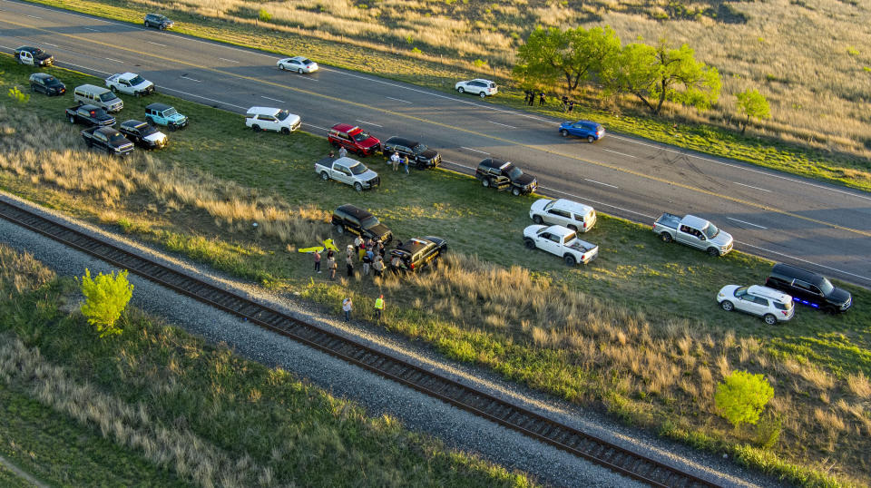 Officials investigate the scene where migrants were found trapped in a train car, Friday, March 24, 2023 in Ulvalde, Texas. Union Pacific railroad said in a statement that the people were found in two cars on the train traveling east from Eagle Pass bound for San Antonio. (William Luther/The San Antonio Express-News via AP)