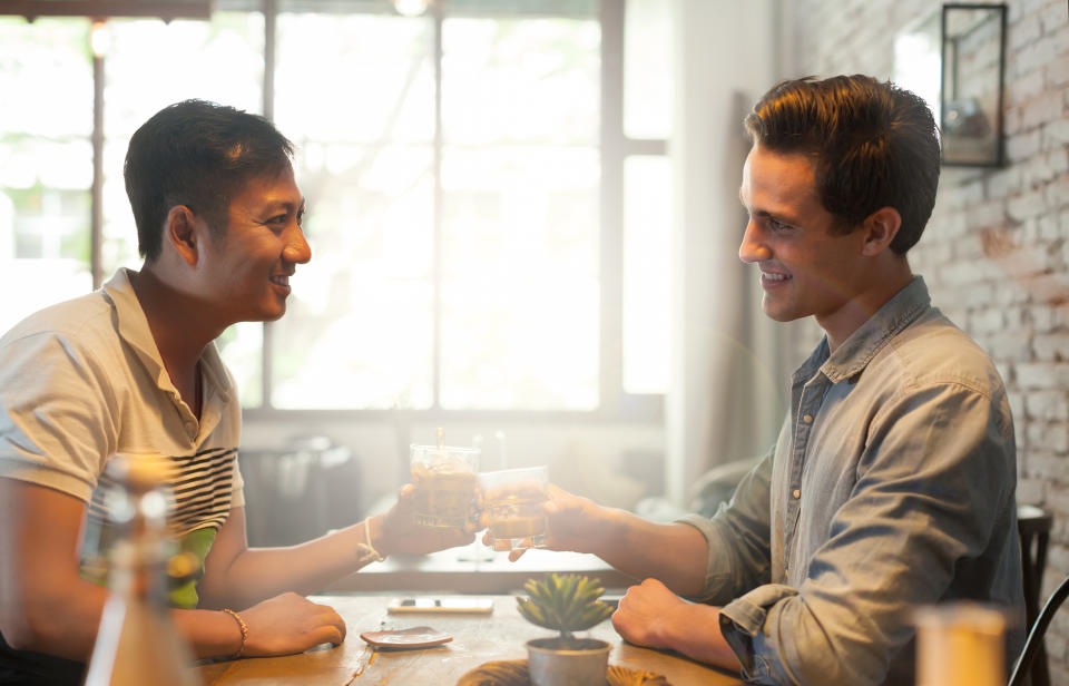 Two men on date, toasting drinks. (Getty Images)