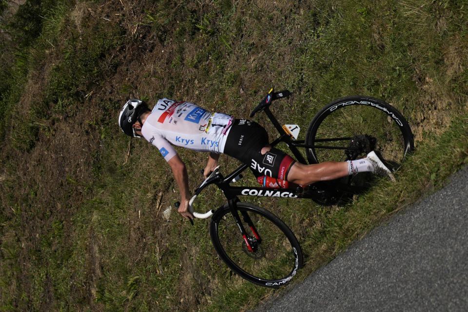 Slovenia's Tadej Pogacar, wearing the best young rider's white jersey, crashes in the descent of the Col de Spandelles pass during the eighteenth stage of the Tour de France cycling race over 143.5 kilometers (89.2 miles) with start in Lourdes and finish in Hautacam, France, Thursday, July 21, 2022. (AP Photo/Daniel Cole)