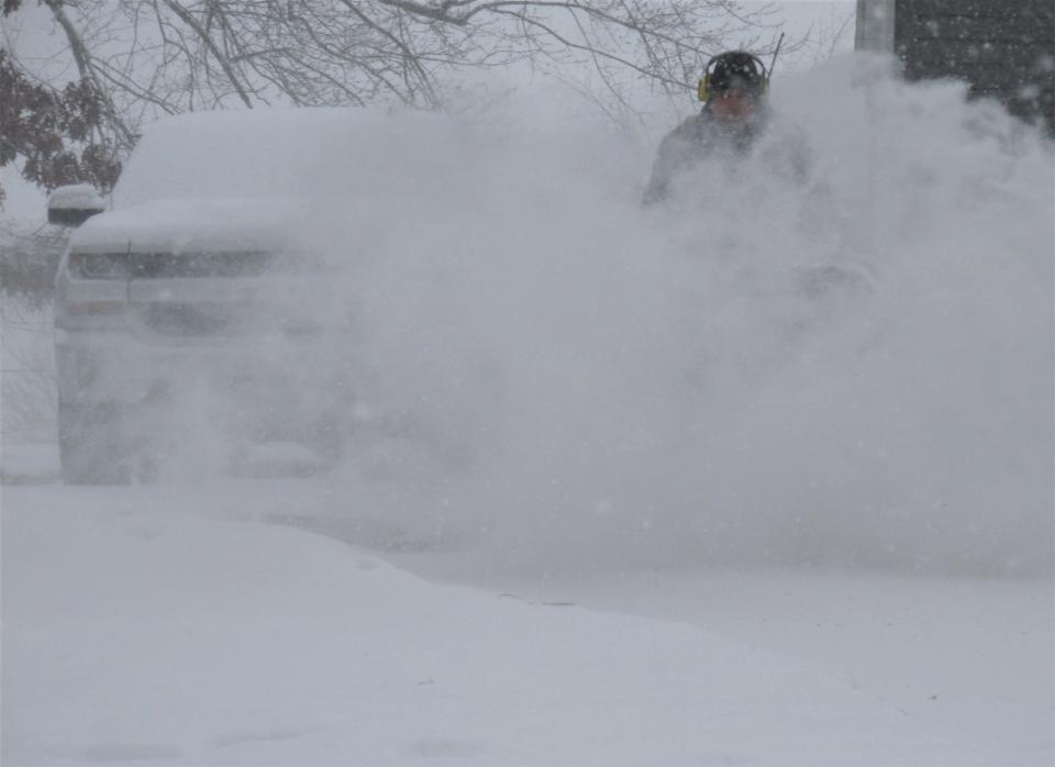 Tony Nickles uses a snowblower to clear his driveway Sunday in Holmes County.