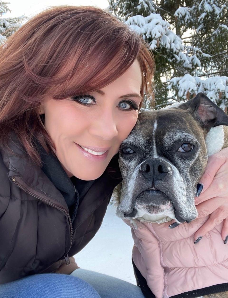 Melissa Melyan poses with Sadie, the dog who inspired her to help find missing dogs.