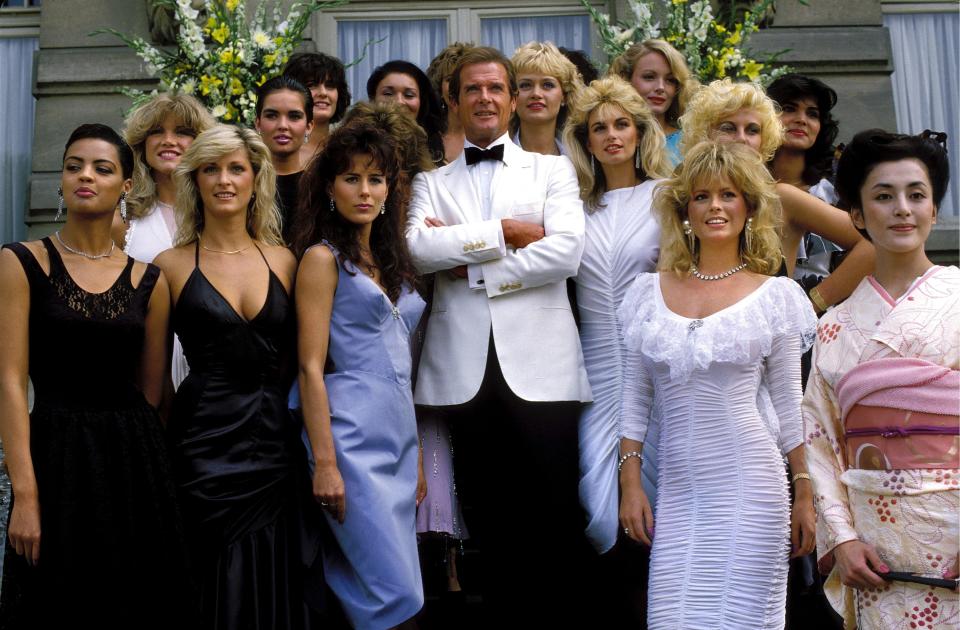 FRANCE - AUGUST 17:  Roger Moore and his James Bond girls in the Film 'A view to kill' in France on August 17th,1984.  (Photo by Chip HIRES/Gamma-Rapho via Getty Images)