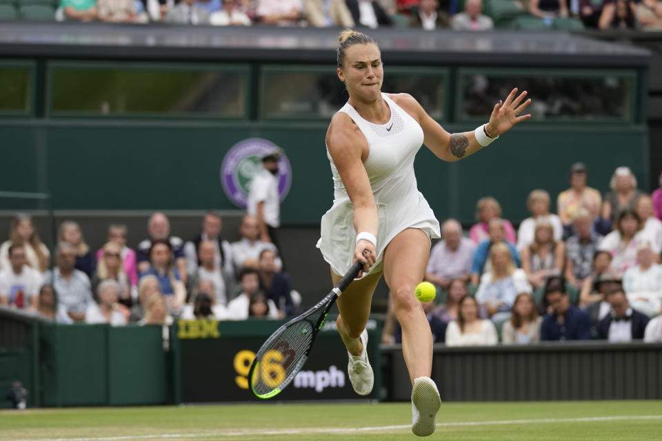 Aryna Sabalenka of Belarus plays a return during the women's singles quarterfinals match against Tunisia's Ons Jabeur on day eight of the Wimbledon Tennis Championships in London, Tuesday, July 6, 2021. (AP Photo/Kirsty Wigglesworth)