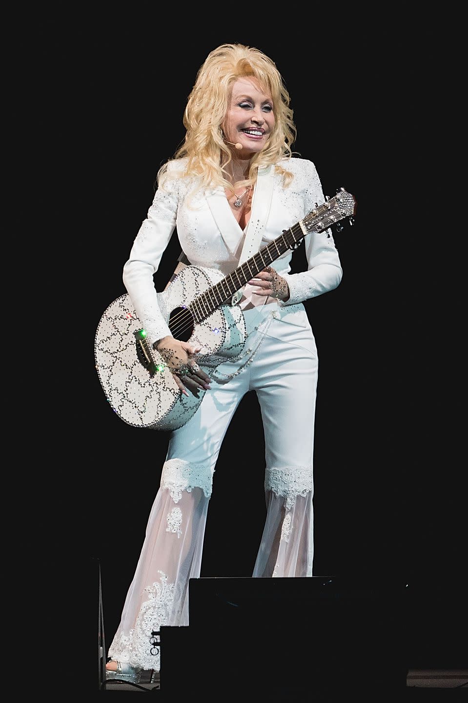<p>Yet again reinventing the pantsuit, Parton shines in this white outfit with lace bell-bottom pants. While the singer still wears plenty of bold colors, she has gravitated back towards neutral colors again in the last two decades. </p>