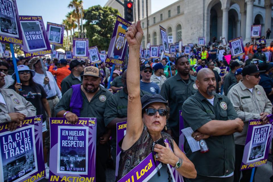 Workers at a rally carrying strike signs.