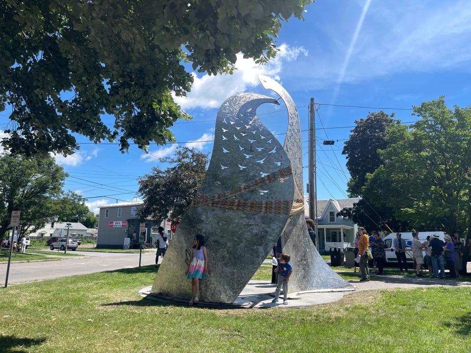 Two children play around the new sculpture "Embrace and Belonging" in Dewey Park before its official unveiling June 26, 2024.