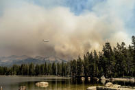 A tanker flies over Wrights Lake while battling the Caldor Fire in Eldorado National Forest, Calif., on Wednesday, Sept. 1, 2021. (AP Photo/Noah Berger)