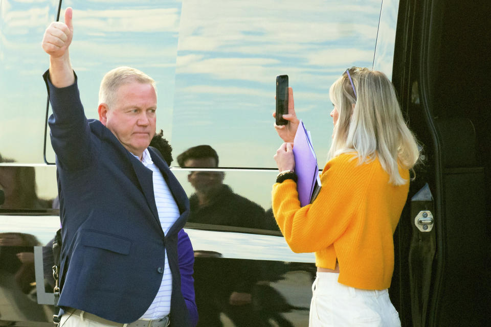 New LSU football coach Brian Kelly gestures to fans after his arrival at Baton Rouge Metropolitan Airport, Tuesday, Nov. 30, 2021, in Baton Rouge, La. Kelly, formerly of Notre Dame, is said to have agreed to a 10-year contract with LSU worth $95 million plus incentives. (AP Photo/Matthew Hinton)