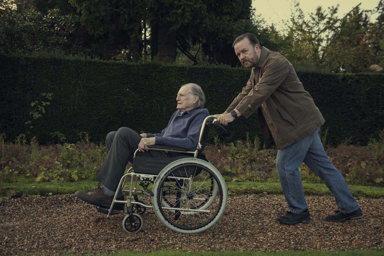 Ricky Gervais pushes David Bradley in a wheelchair in this still from <i>After Life</i>. (Netflix)