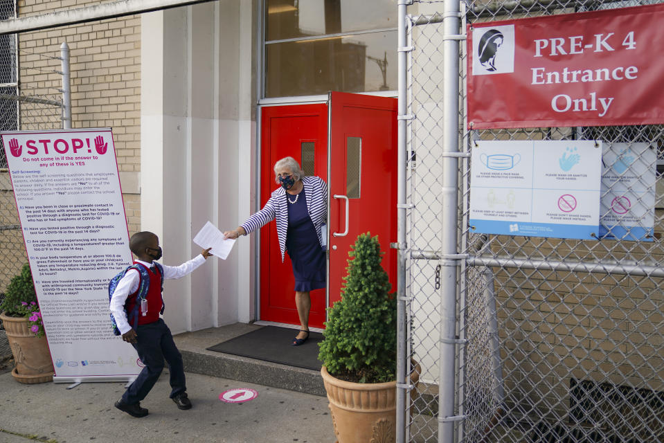 FILE - In this Sept. 9, 2020, file photo, a student wears a protective masks as they arrive for classes at the Immaculate Conception School while observing COVID-19 prevention protocols in The Bronx borough of New York. New York City has again delayed the planned start of in-person learning for most of the more than 1 million students in its public school system. Mayor Bill de Blasio announced Thursday, Sept. 17, that most elementary school students would do remote-only learning until Sept. 29. Middle and high schools would stay remote through Oct. 1.(AP Photo/John Minchillo)