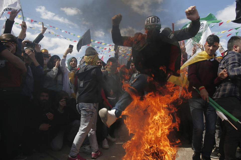 A man jumps over a fire as thousands of supporters of pro-Kurdish Peoples' Democratic Party, or HDP, gather to celebrate the Kurdish New Year and to attend a campaign rally for local elections that will test the Turkish president's popularity, in Istanbul, Sunday, March 24, 2019. The HDP held the event amid the municipal office races that have become polarizing and a government crackdown on its members for alleged links to outlawed Kurdish militants. (AP Photo/Emrah Gurel)