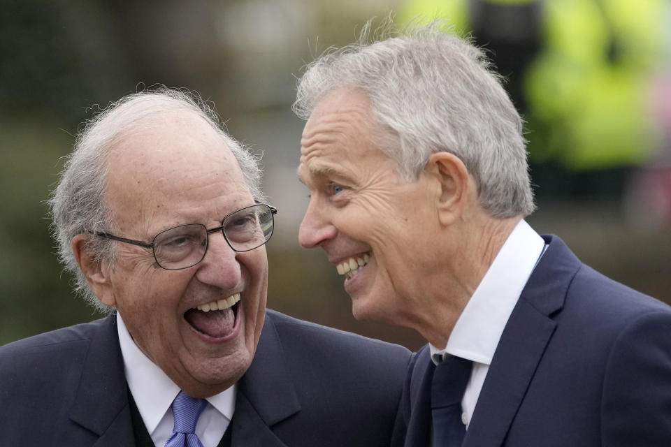 Britain's former Prime Minister Tony Blair, right, and former U.S. Sen. George Mitchell are all smiles during the bust unveiling on the first day of a three-day international conference at Queen's University Belfast to mark the 25th anniversary of the Good Friday Agreement, in Belfast, Northern Ireland, Monday, April 17, 2023. Former U.S. President Bill Clinton and past leaders of the U.K. and Ireland are gathering in Belfast on Monday, 25 years after their charm, clout and determination helped Northern Ireland strike a historic peace accord. (AP Photo/Christophe Ena)