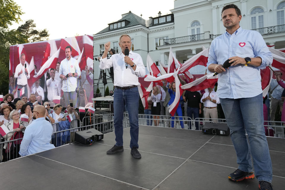 Poland's opposition leader and former prime minister, Donald Tusk, left, and his Civic Platform member, Warsaw Mayor Rafal Trzaskowski, right, stand on stage during an election campaign rally in Otwock, Poland, on Monday, Sept. 25, 2023. (AP Photo/Czarek Sokolowski)