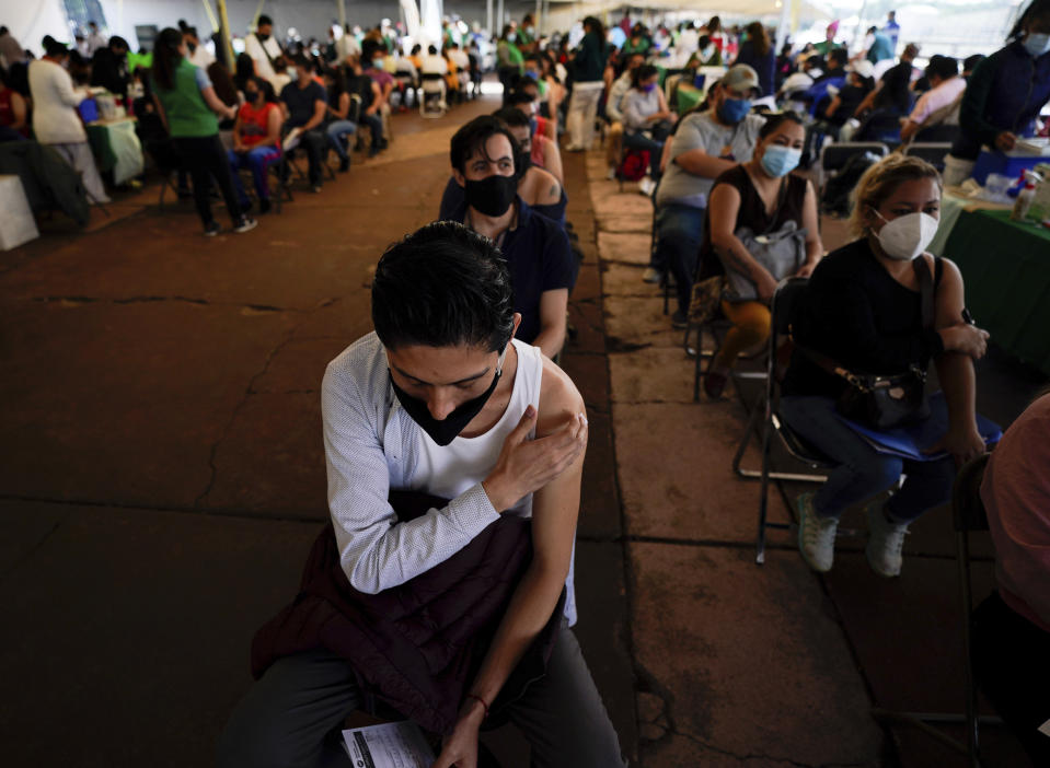 A youth keeps his hand on the spot where he was vaccinated with Russia's Sputnik V coronavirus vaccine during a vaccination drive at University Stadium in Mexico City, Friday, July 23, 2021. So far, about 42.4 million people have been vaccinated, according to the health ministry. That is about 47% of the adult population, and about 30% of the total population. (AP Photo/Fernando Llano)