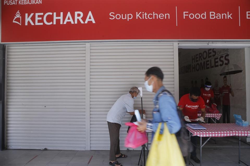 The homeless and needy line up in front of Kechara Soup Kitchen in KL every day to collect free meals. ― Picture by Hari Anggara