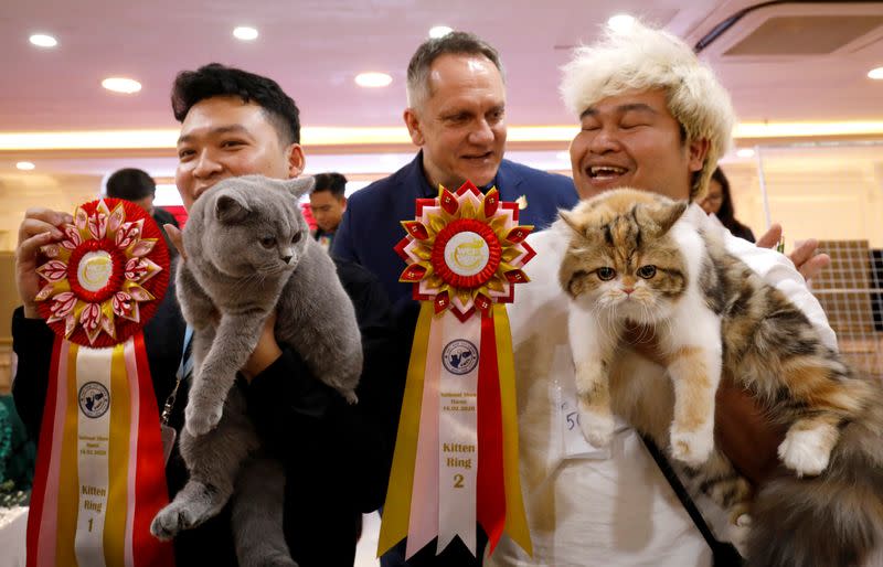 Vice chairman of World Cat Federation Albert Kurkowski presents first title to the cat of Nguyen Xuan Son of Vietnam and second title to the cat of Tawin Prai of Thailand during the Vietnam's first cat show in Hanoi