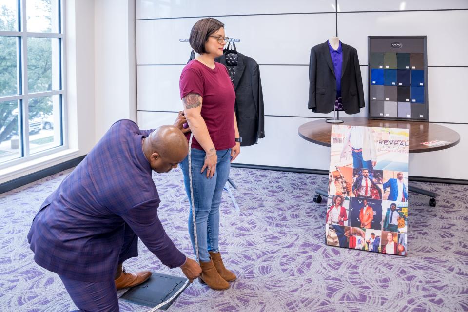 Carlton Dixon, owner of Reveal Suits, measures Texas Christian University student Renee Perez, 38, for a professional suit. Many universities now provide professional clothing to their students to help them prepare for the workplace.