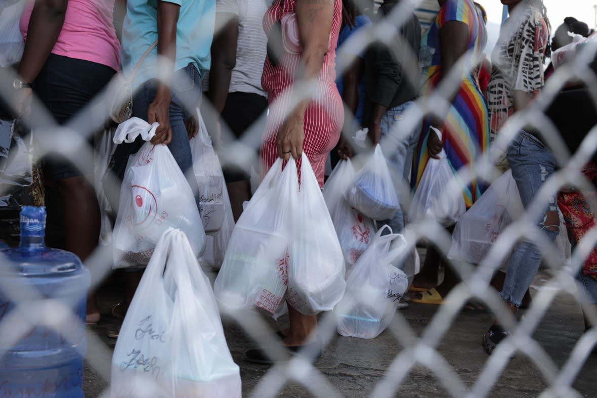 People gather outside the National Penitentiary for their turn to deliver food to their jailed relatives in downtown Port-au-Prince, Haiti, Thursday, June 1, 2023. In December 2022, the University of Florida published a study that found that men in Haiti’s prisons were on a starvation-level diet, consuming fewer than 500 calories a day. (AP Photo/Odelyn Joseph)