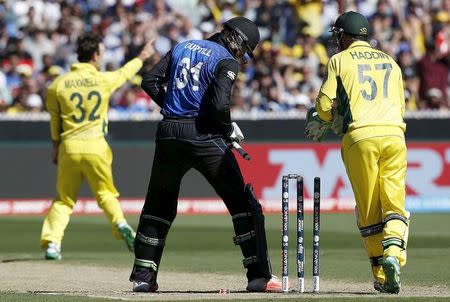 New Zealand's Martin Guptill (C) reacts after being bowled by Australia's Glenn Maxwell (L) for 15 runs during their Cricket World Cup final match at the Melbourne Cricket Ground (MCG) March 29, 2015. REUTERS/Jason Reed