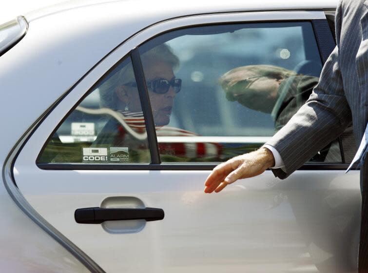 Santa Barbara News-Press owner and co-publisher Wendy McCaw, left, sits inside a car, as Santa Barbara News-Press co-publisher and fiance, Arthur von Wiesenberger, right reflected on car window, assists her with the door, as they return to the United States Bankruptcy Court building in Santa Barbara, Calif., Tuesday, Sept. 25, 2007. McCaw testified that concerns about biased reporting, not union activity in the newsroom, led to the firing of two reporters last January. (AP Photo/Damian Dovarganes)
