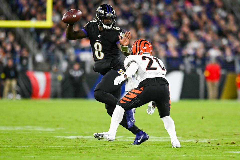 Baltimore Ravens quarterback Lamar Jackson runs as Cincinnati Bengals cornerback Mike Hilton applies pressure.