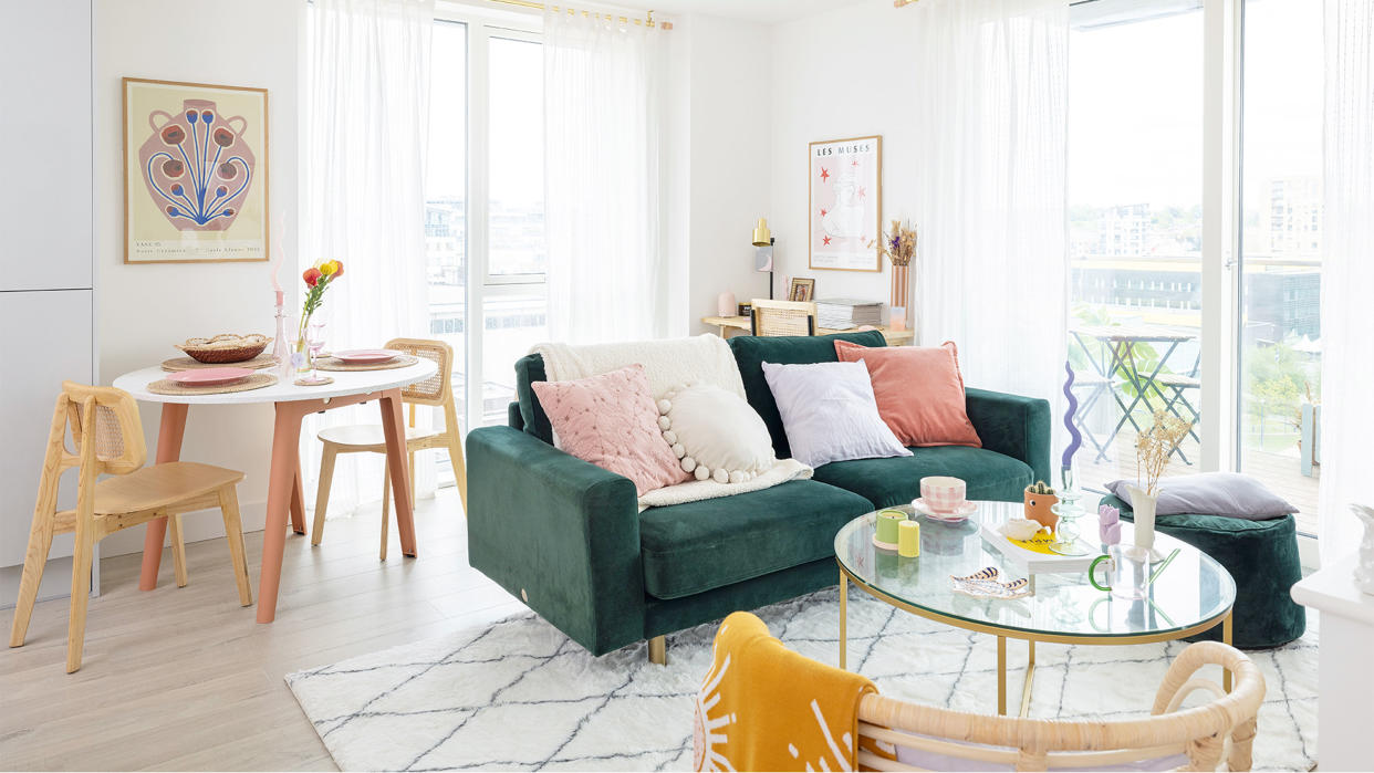  open plan living area with green velvet sofa and glass coffee table 