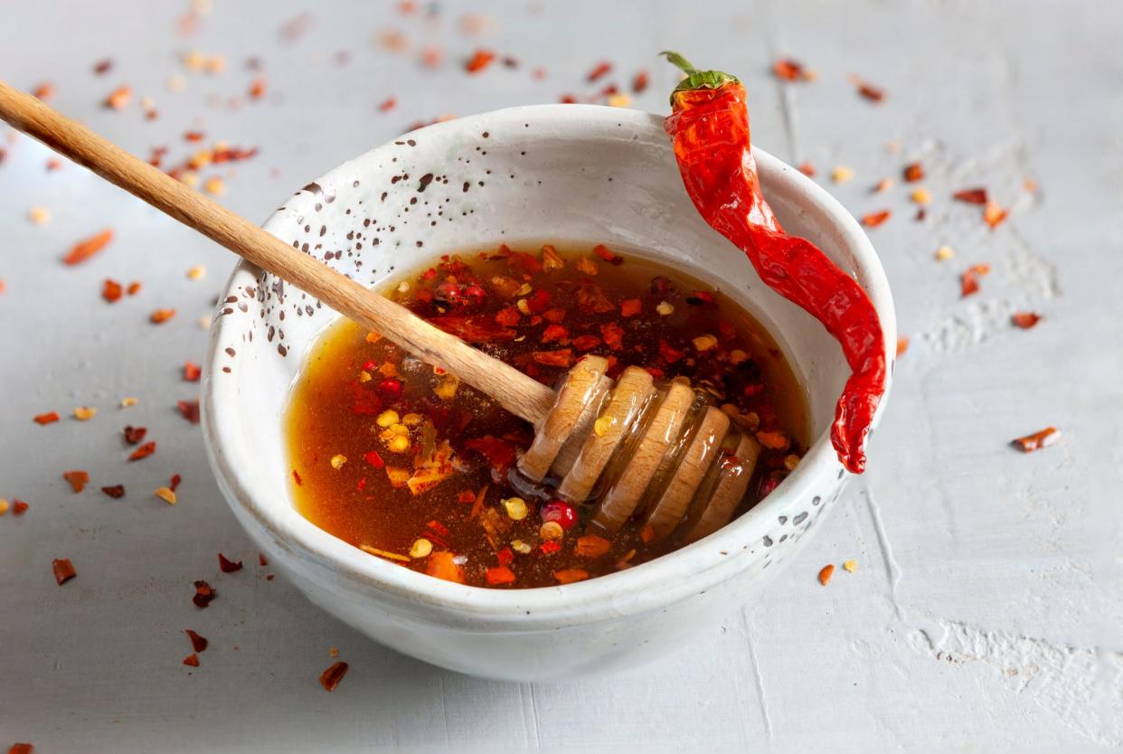 Hot honey in the bowl with dry chili pepper