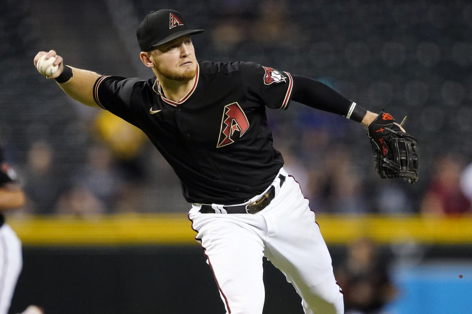 Arizona Diamondbacks' Josh VanMeter fields a ground out hit by Atlanta Braves' Dansby Swanson during the first inning of a baseball game, Wednesday, Sept. 22, 2021, in Phoenix. (AP Photo/Matt York)