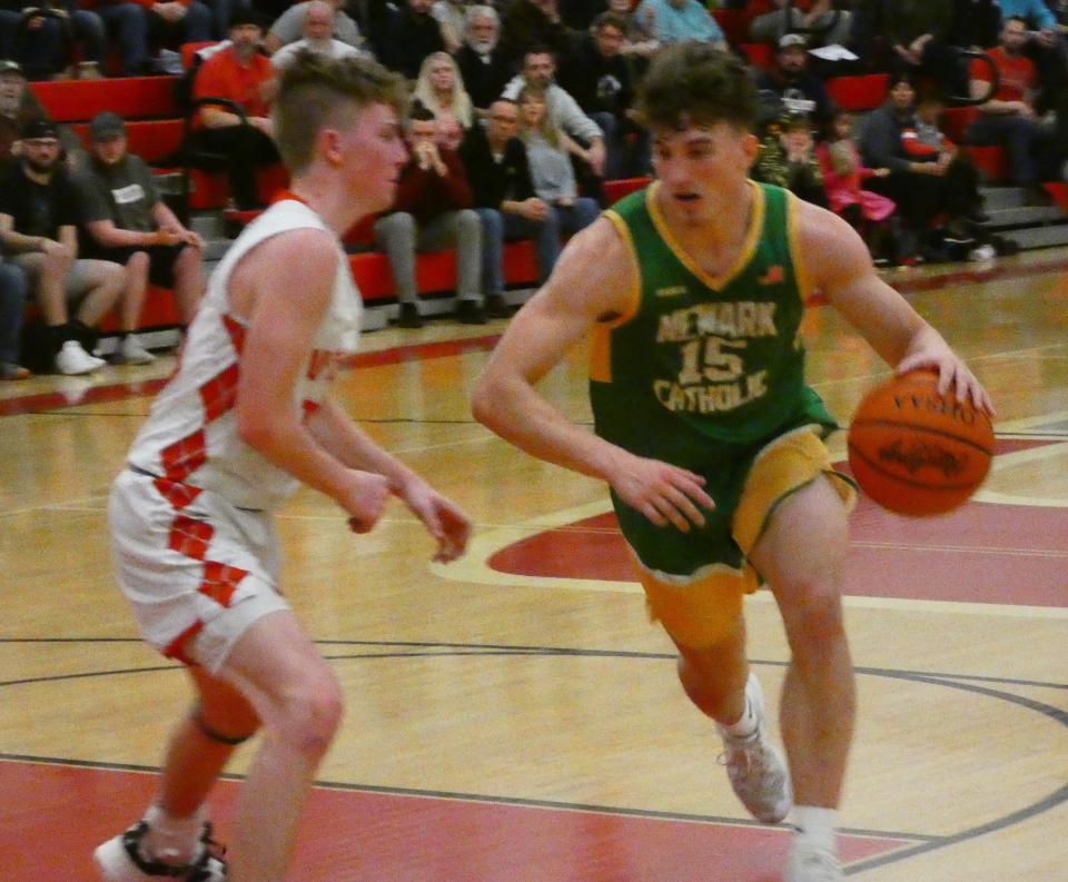 Newark Catholic junior Kyle Langenbrunner drives from the elbow against Utica sophomore Roman Gamble on Friday, Jan. 28, 2022. The visiting Green Wave earned a 70-66 victory.