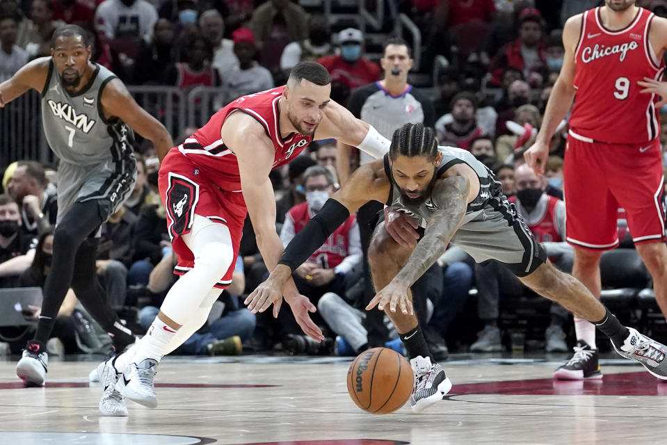 RETRANSMISSION TO REMOVE SCORE - Chicago Bulls' Zach LaVine, left, and Brooklyn Nets' DeAndre' Bembry battle for a loose ball during the first half of an NBA basketball game Wednesday, Jan. 12, 2022, in Chicago. (AP Photo/Charles Rex Arbogast)
