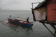 A resident secures his boat as Typhoon Noru approaches the seaside slum district of Tondo in Manila, Philippines, Sunday, Sept. 25, 2022. The powerful typhoon shifted and abruptly gained strength in an "explosive intensification" Sunday as it blew closer to the northeastern Philippines, prompting evacuations from high-risk villages and even the capital, which could be sideswiped by the storm, officials said. (AP Photo/Aaron Favila)