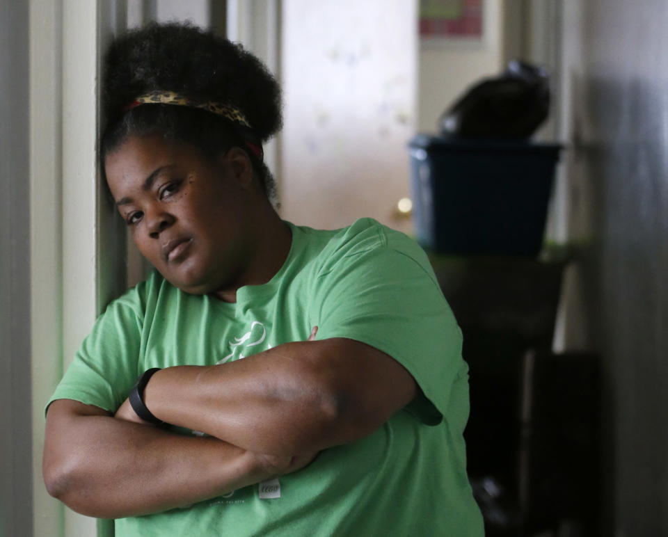In this Thursday, March 30, 2017, photo, Tara Adams poses for a portrait in her home as boxes sit stacked in a hallway waiting for an impending move from her East Chicago, Ind., home. Adams is one of dozens of families in this former industrial town who have yet to be evacuated from a housing project ordered emptied by the mayor because of severe lead contamination. (AP Photo/Charles Rex Arbogast)