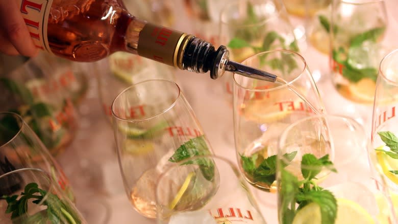 Lillet Blanc being poured from a bottle into wine glasses