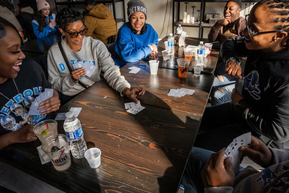 From left, Nakisha Johnson, Ebonie Davis, Nicole Dismute, Tasha Powell, Tiesha Lawson and Korry Powell play a round of spades while waiting for the Lions game to begin on Sunday, Jan. 21, 2024, at The Shadow Gallery in Detroit.