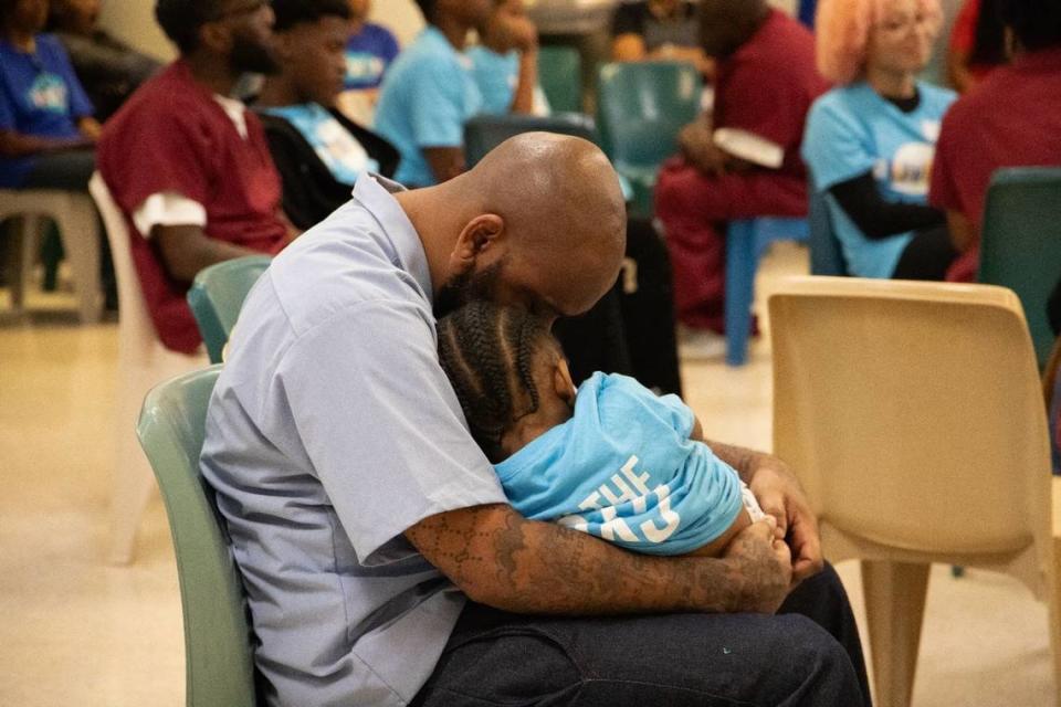 A father embraces his young son during a Proverbs226 prison event at Sussex State Prison in Virginia. July 2023.