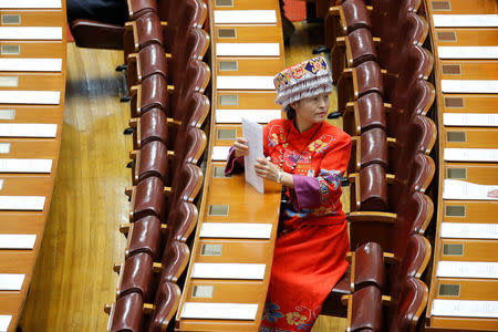 A delegate wearing traditional costume prepares for the opening session. REUTERS/Thomas Peter
