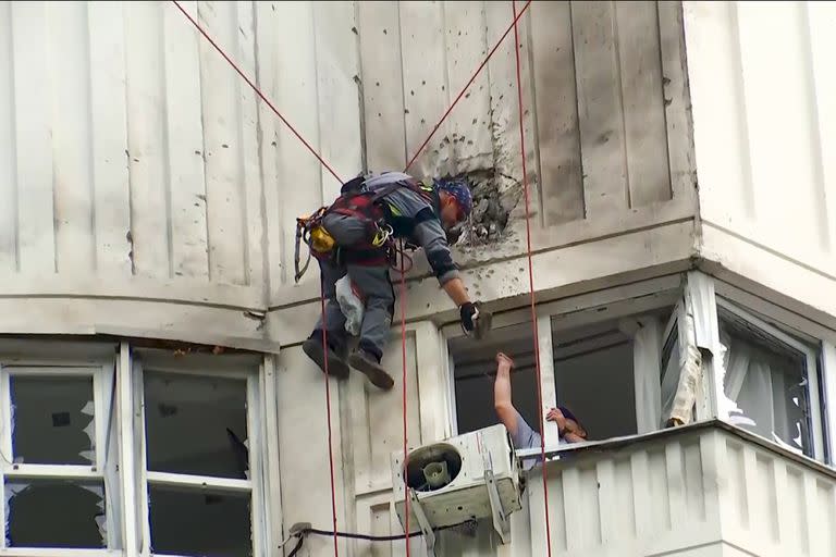 En esta imagen tomada de un video, los investigadores inspeccionan el edificio después de un ataque de un dron ucraniano en Moscú, Rusia, el martes 30 de mayo de 2023. 