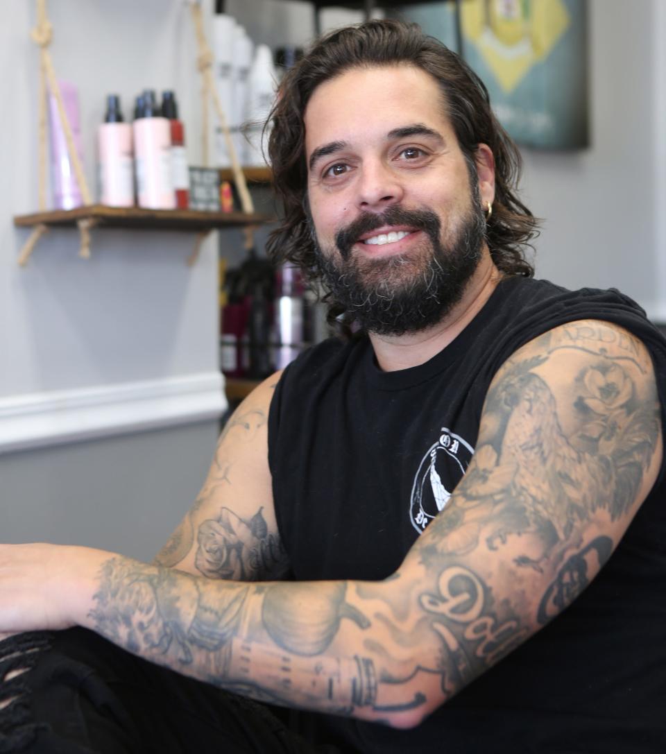 Ryan Pepe, owner of Salon De La Warr, shows off his left arm, which has over a dozen Delaware-related tattoos, during a visit at his business on Nov. 17, 2022.