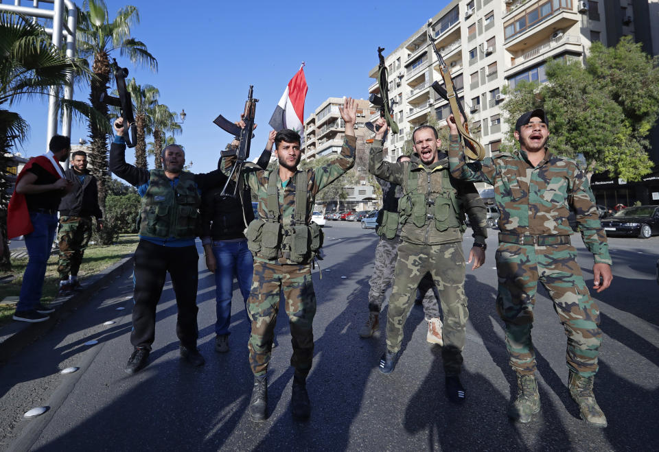 <p>Syrian soldiers hold their weapons as they dance and chant slogans against U.S. President Trump during demonstrations following a wave of U.S., British and French military strikes to punish President Bashar Assad for suspected chemical attack against civilians, in Damascus, Syria, Saturday, April 14, 2018. (Photo: Hassan Ammar/AP) </p>