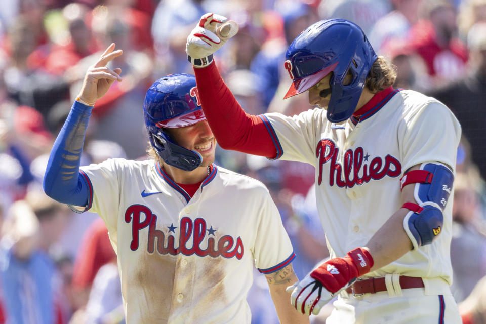 Philadelphia Phillies third baseman Alec Bohm, left, celebrates with Bryson Stott after they both scored on Bohm's home run during the fourth inning of a baseball game against the Cincinnati Reds, Sunday, April 9, 2023, in Philadelphia. (AP Photo/Laurence Kesterson)
