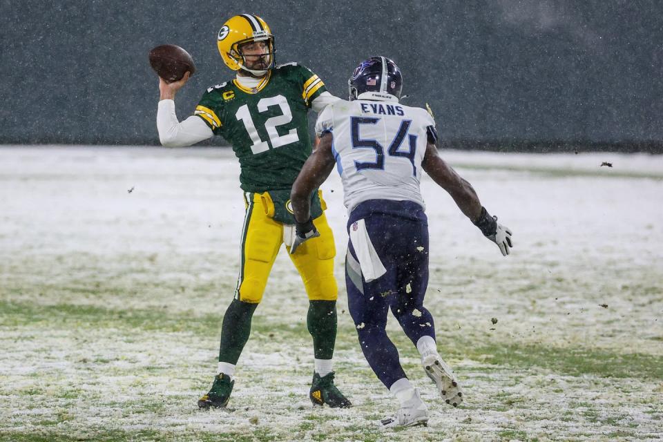 Rodgers initiates a pass with an opposing player coming at him
