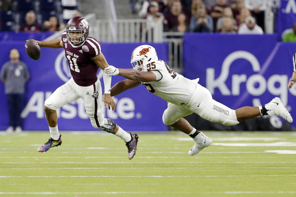 Texas A&M quarterback Kellen Mond (11) slips the tackle attempt by Oklahoma State defensive tackle Israel Antwine (95) during the second half of the Texas Bowl NCAA college football game Friday, Dec. 27, 2019, in Houston. (AP Photo/Michael Wyke)