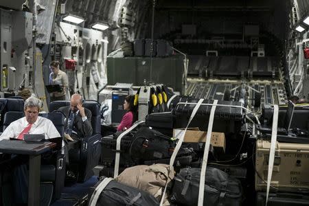 U.S. Secretary of State John Kerry (front L) looks over papers while flying from Jordan to Iraq September 10, 2014. REUTERS/Brendan Smialowski/Pool