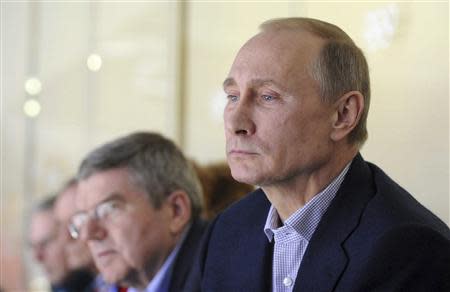 Russia's President Vladimir Putin (R) watches the men's preliminary round ice hockey game between Russia and the U.S. at the Sochi 2014 Winter Olympic Games February 15, 2014. REUTERS/Mikhail Klimentyev/RIA Novosti/Kremlin