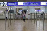 A girl wearing a mask skips rope at Incheon International Airport in Incheon, South Korea, Monday, Jan. 27, 2020. China on Monday expanded sweeping efforts to contain a viral disease by extending the Lunar New Year holiday to keep the public at home and avoid spreading infection. (AP Photo/Ahn Young-joon)