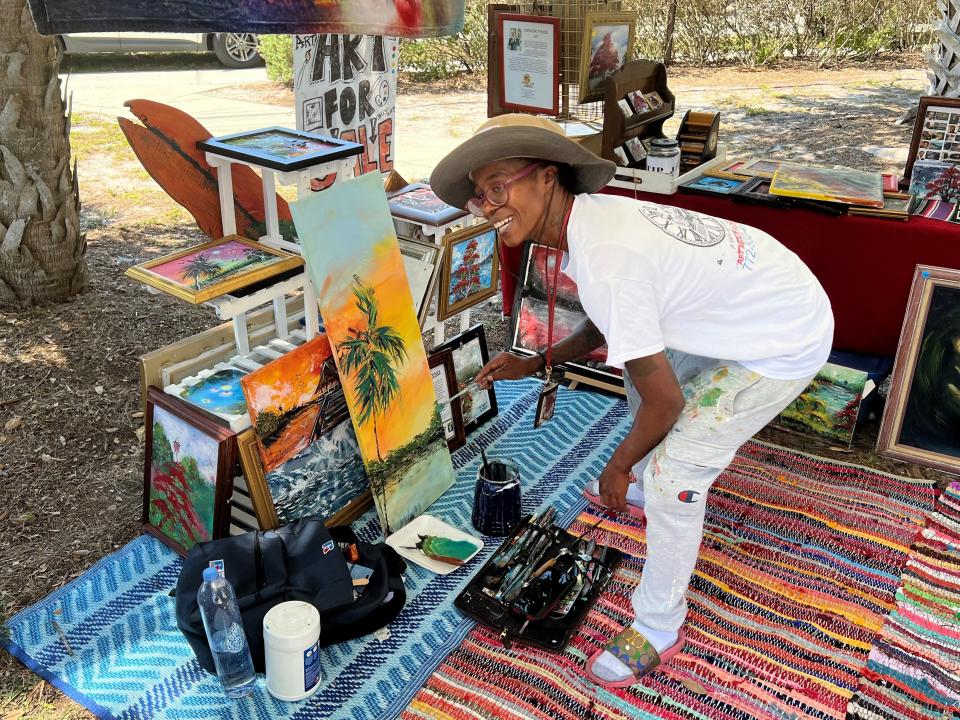 Dominique Tynes, a vendor at the Gifford Community Cultural and Resource Center's second annual Emancipation Day, paints a palm tree Saturday.