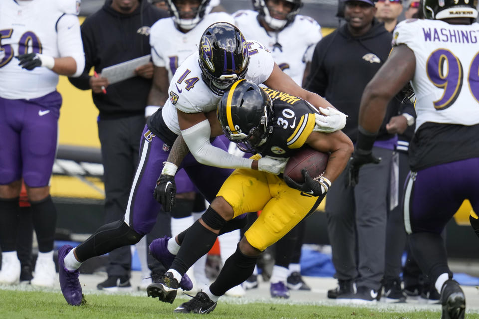 Baltimore Ravens safety Kyle Hamilton (14) tackles Pittsburgh Steelers running back Jaylen Warren (30) in the first half of an NFL football game in Pittsburgh, Sunday, Oct. 8, 2023. (AP Photo/Gene J. Puskar)