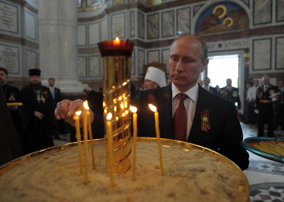 Russian President Vladimir Putin lights a candle in Sevastopol where he attends celebrations marking the Victory Day, in Crimea, Friday, May 9, 2014. President Vladimir Putin hailed the return of Crimea to Russia as the restoration of "historic justice" before a jubilant, welcoming crowd Friday on the holiday that Russians hold dearest. Putin's visit to the Crimean port of Sevastopol, was strongly criticized by both NATO and Ukraine's Foreign Ministry. (AP Photo/RIA-Novosti, Alexei Druzhinin, Presidential Press Service)