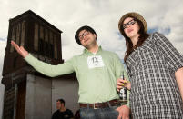 BERLIN, GERMANY - JULY 21: Attendees Rudi Kraft (L) and Lina Szmielkin greet friends at the second annual Hipster Olympics on July 21, 2012 in Berlin, Germany. With events such as the "Horn-Rimmed Glasses Throw," "Skinny Jeans Tug-O-War," "Vinyl Record Spinning Contest" and "Cloth Tote Sack Race," the Hipster Olympics both mocks and celebrates the Hipster subculture, which some critics claim could never be accurately defined and others that it never existed in the first place. The imprecise nature of determining what makes one a member means that the symptomatic elements of adherants to the group vary in each country, but the archetype of the version in Berlin, one of the more popular locations for those following its lifestyle, along with London and Brooklyn, includes a penchant for canvas tote bags, the carbonated yerba mate drink Club Mate, analogue film cameras, an asymetrical haircut, 80s neon fashion, and, allegedly, a heavy dose of irony. To some in Berlin, members of the hipster "movement" have replaced a former unwanted identity in gentrifying neighborhoods, the Yuppie, for targets of criticism, as landlords raise rents in the areas to which they relocate, particularly the up-and-coming neighborhood of Neukoelln. (Photo by Adam Berry/Getty Images)